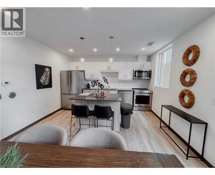 A modern kitchen with white cabinets and a wooden island.