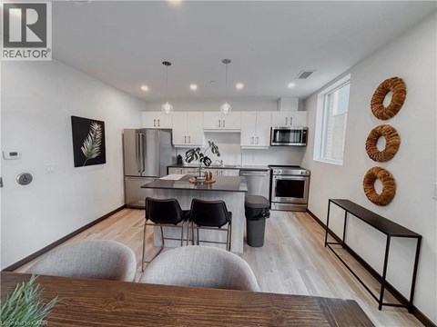 A modern kitchen with white cabinets and a wooden island.