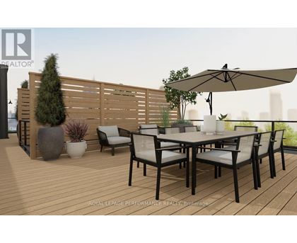 A wooden deck with a table and chairs and a large umbrella.