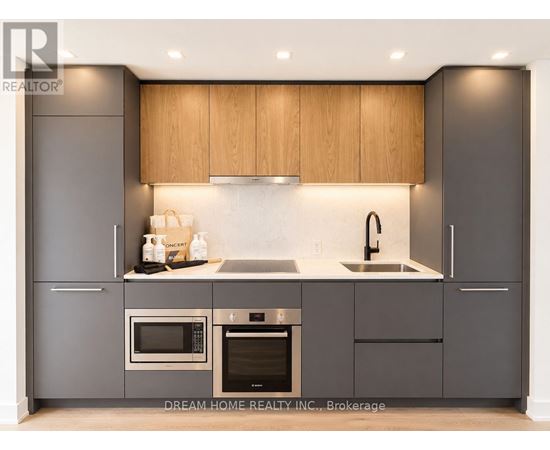 A modern kitchen with wooden cabinets and stainless steel appliances.