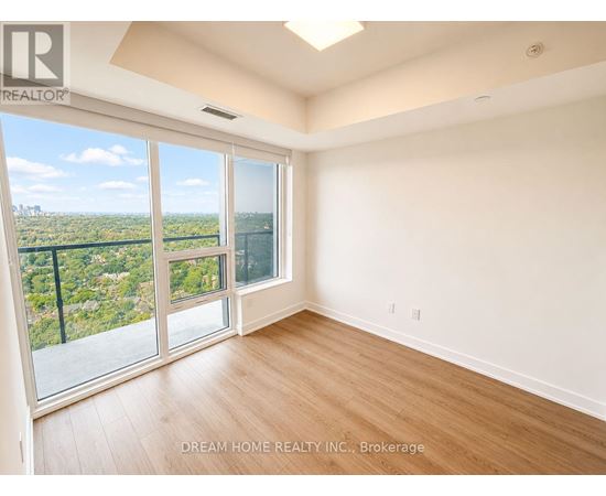 A room with a view of a cityscape through large windows.
