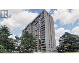 A tall residential building with a fence in front of it.