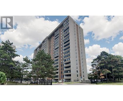 A tall residential building with a fence in front of it.