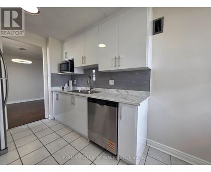A kitchen with white cabinets and a stainless steel dishwasher.