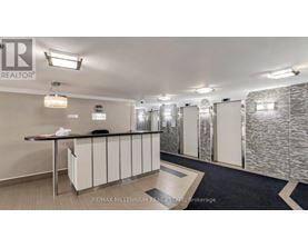 A well-lit office space with a reception desk and a stone wall.