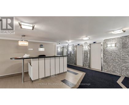 A well-lit office space with a reception desk and a stone wall.