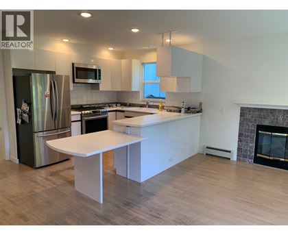 A modern kitchen with a refrigerator, stove, and island.