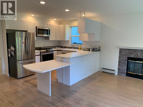 A modern kitchen with a refrigerator, stove, and island.