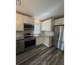 A kitchen with stainless steel appliances and white cabinets.