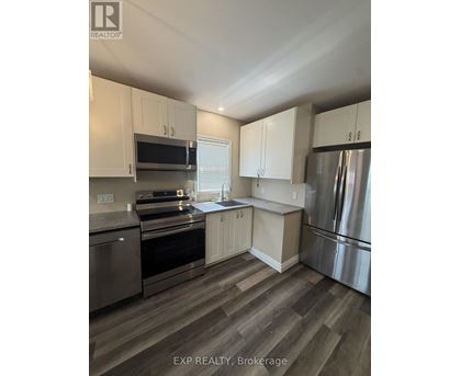 A kitchen with stainless steel appliances and white cabinets.