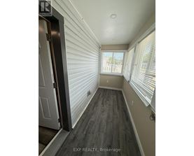 A hallway with wood flooring and white walls.