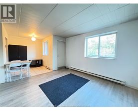 A room with a table and chairs and a window.
