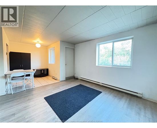 A room with a table and chairs and a window.