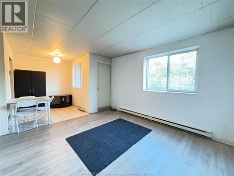 A room with a table and chairs and a window.