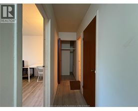 A hallway with a table and chairs on the left and a door on the right.