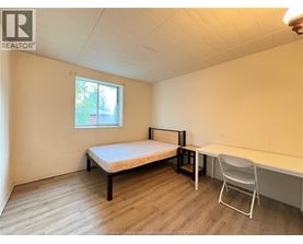 A bedroom with a bed, desk, and chair.