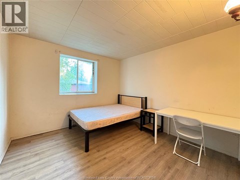 A bedroom with a bed, desk, and chair.