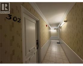 A hallway with a door on the left and a fire extinguisher on the wall.