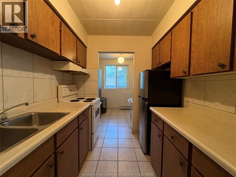 A kitchen with wooden cabinets and a black refrigerator.