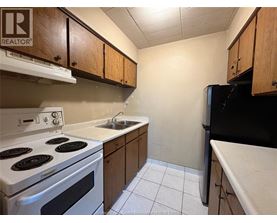 A kitchen with a white stove and black refrigerator.