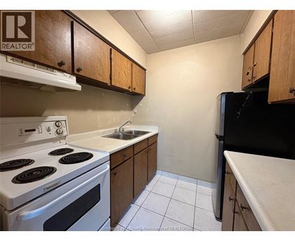 A kitchen with a white stove and black refrigerator.