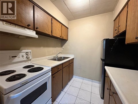 A kitchen with a white stove and black refrigerator.
