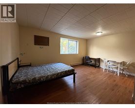 A bedroom with a bed, chair, and table.