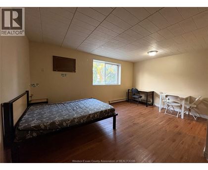 A bedroom with a bed, chair, and table.
