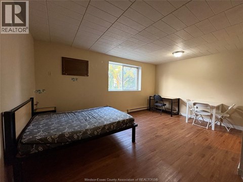 A bedroom with a bed, chair, and table.