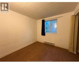 A room with a window and a curtain.