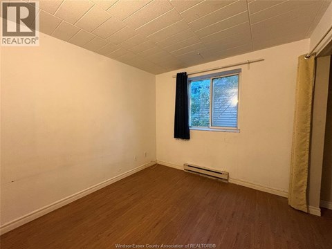 A room with a window and a curtain.