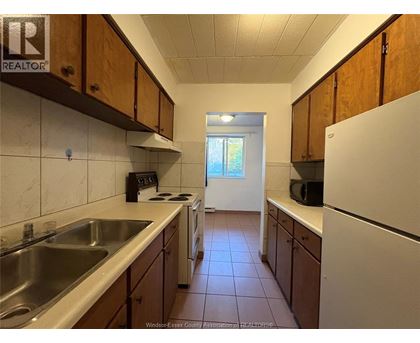 A kitchen with wooden cabinets and a white refrigerator.