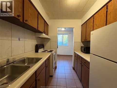 A kitchen with wooden cabinets and a white refrigerator.