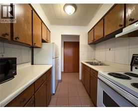 A kitchen with white appliances and brown cabinets.