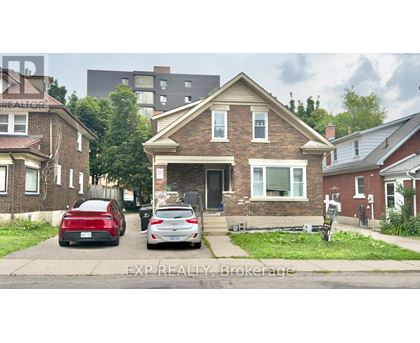 A house with a red car and a white car parked in front.