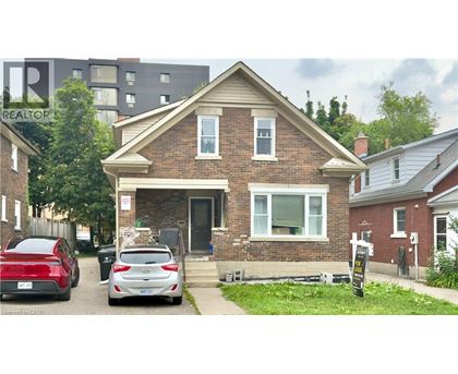 A brick house with a car parked in front.