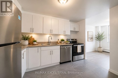 A modern kitchen with white cabinets and stainless steel appliances.