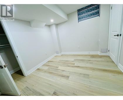 A room with wooden flooring and white walls.