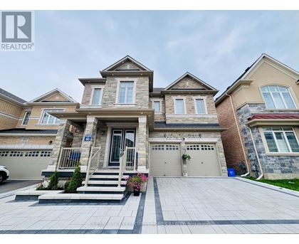A large, two-story house with a garage and a driveway in front.
