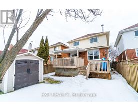 A snow-covered backyard with a wooden deck and a detached house.