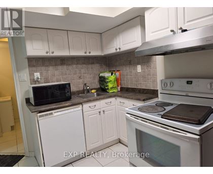 A kitchen with white cabinets and a white stove top oven.