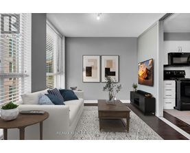 A modern living room with a white sofa, a coffee table, and a TV.