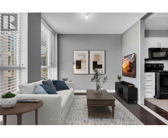 A modern living room with a white sofa, a coffee table, and a TV.