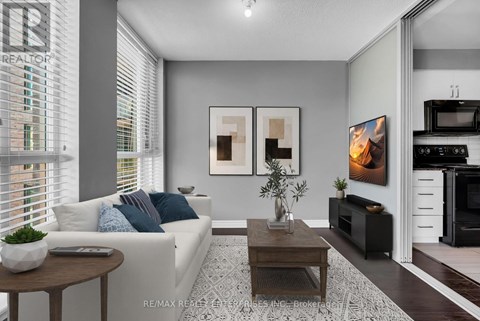 A modern living room with a white sofa, a coffee table, and a TV.