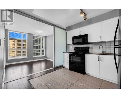 A kitchen with white cabinets and a black oven.