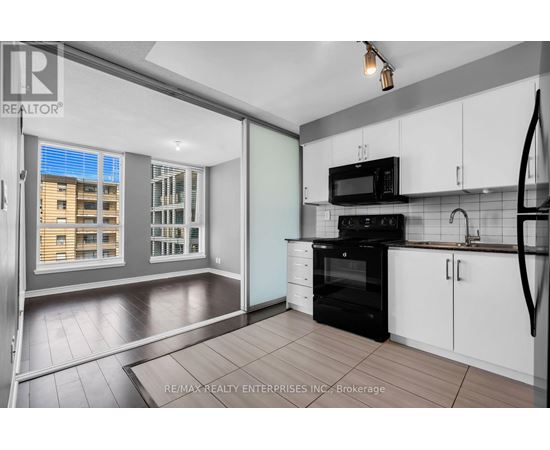 A kitchen with white cabinets and a black oven.