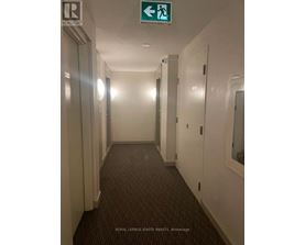 A hallway with a green exit sign above it.