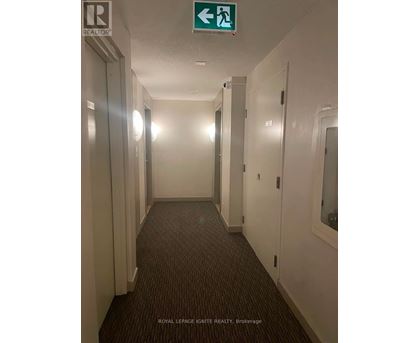 A hallway with a green exit sign above it.