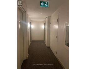 A hallway with a green exit sign above it.