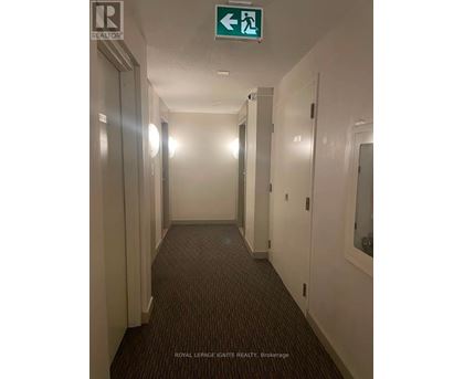 A hallway with a green exit sign above it.